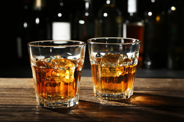 Glasses of whisky on wooden bar closeup