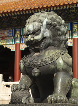 Outside the Chinese Imperial Palace, a Chinese Guardian Lion, a Foo Dog with his right paw on a globe.