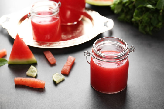 Watermelon smoothie with mint and lime slices on table