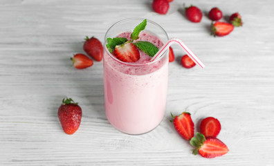 Fresh milkshake with strawberry on wooden background