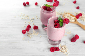 Fresh milkshake with raspberry and oatmeal on wooden background