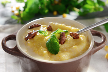 Delicious cornmeal porridge with walnuts and mint, closeup