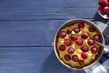 Delicious cornmeal porridge with raspberry on blue wooden table