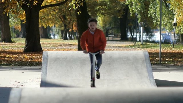 Teenage Boy on Skateboard Ramp in Autumn