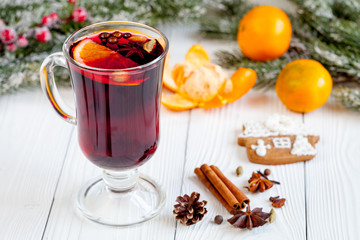 Christmas mulled wine with spices in cup on wooden background