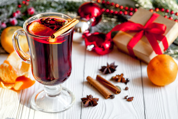 Christmas mulled wine with spices in cup on wooden background