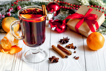 Christmas mulled wine with spices in cup on wooden background