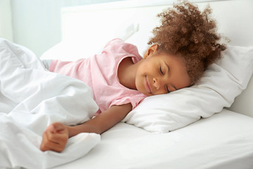 Little African American girl resting in bed