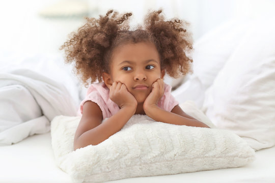 Little African American girl resting in bed