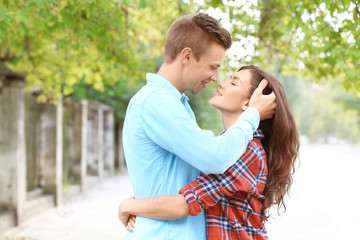 Fototapeta premium Beautiful young couple outdoors on blurred background