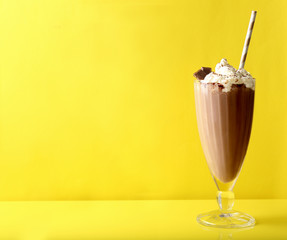 Delicious milkshake on yellow background