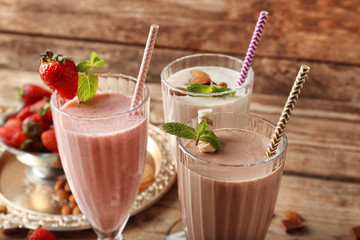 Delicious milkshakes on wooden background