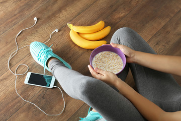 Athletic girl with healthy food on floor