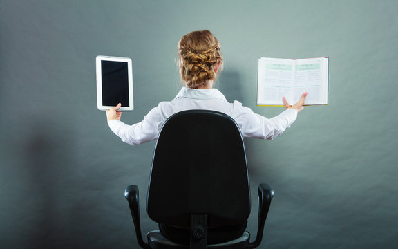 Woman holding traditional book and e-book reader