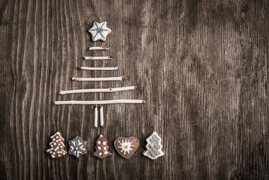 Christmas tree made of branches and gingerbread cookie as background