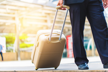 Business man hold a luggage case and walk in the city. Business trip. Business  in the city concept.