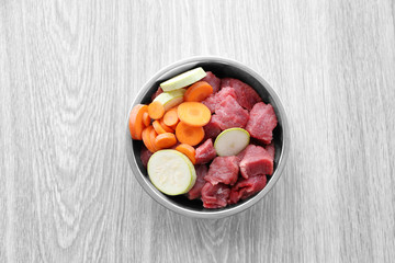 Obraz na płótnie Canvas Organic dog food in a bowl on a wooden floor