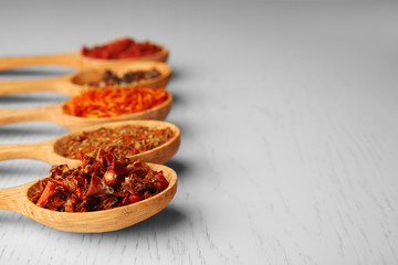 Spices in spoons on a wooden background