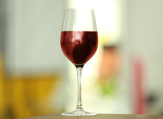 Glass with red wine on table