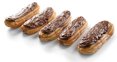 Delicious eclairs with chocolate in a row on white background