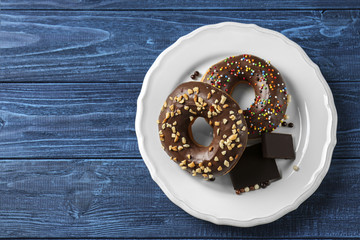 Tasty donuts with chocolate pieces on table