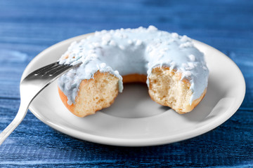 Bitten donut with fork on table