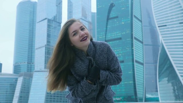 Girl posing against the backdrop of a skyscraper
