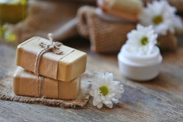 Fototapeta na wymiar Spa concept. Soap and daisy flowers on wooden table