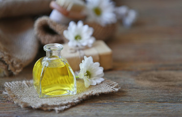 Obraz na płótnie Canvas Spa concept. Aroma oil and daisy flowers on wooden table