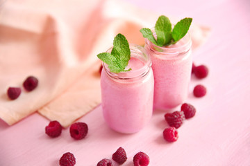 Berry milkshakes on color background