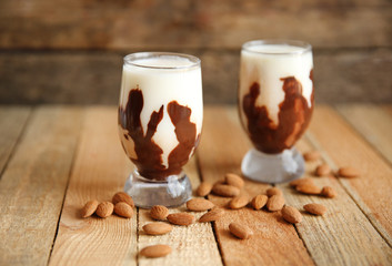 Milkshakes with almonds on wooden table
