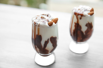 Milkshakes with almonds on wooden table