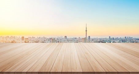 Empty wood table top on panoramic modern cityscape building under sunrise and morning blue bright sky background for display or montage product