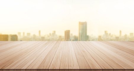 Empty wood table top on panoramic modern cityscape building under sunrise and morning blue bright sky background for display or montage product