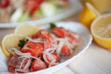 salad with onion and salmon on a white wood background
