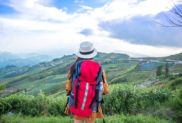 Fototapeta na wymiar Hiker woman look binoculars on the mountain, background blue sky, Thailand, select and soft focus