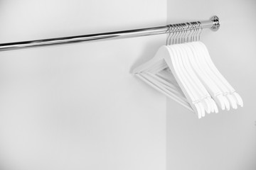 Clothes hangers in empty wardrobe, closeup