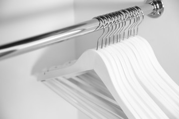 Clothes hangers in empty wardrobe, closeup