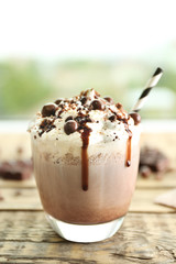 Delicious milk dessert with chocolate on wooden table and blurred background