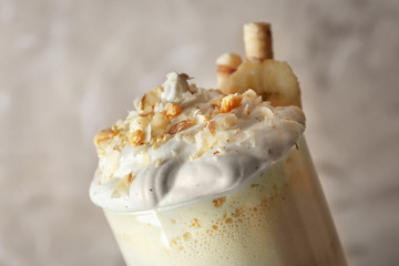 Delicious banana milkshake with sweets on beige background, closeup