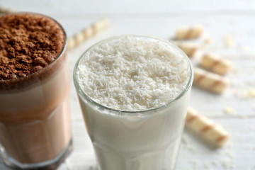 Delicious milkshakes on wooden table closeup