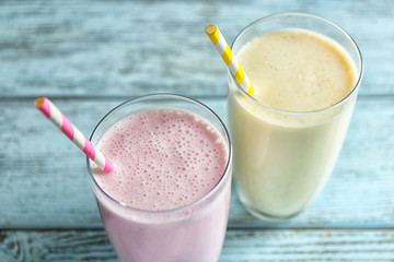 Delicious fruit milkshakes on wooden background