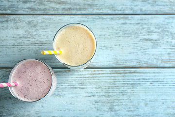 Delicious fruit milkshakes on wooden background