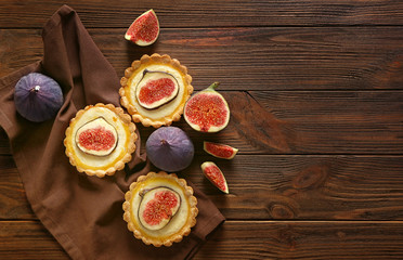 Tasty cake with figs and fresh fruits on wooden background