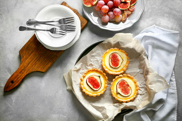Tasty cakes with figs on baking tray, top view