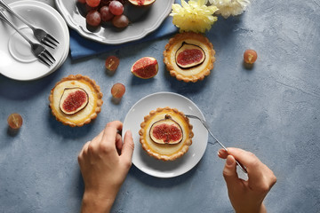 Woman with fork and knife ready to eat fig cake, top view