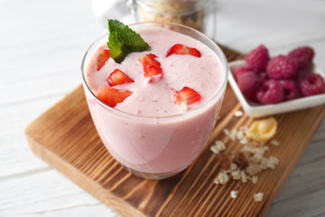 Healthy and tasty breakfast of berry milkshake with mint on wooden board