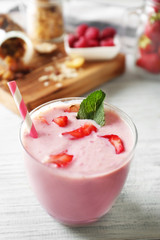 Healthy and tasty breakfast of berry milkshake with mint on wooden table