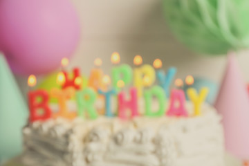 Blurred Birthday cake with candles on light background