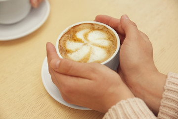 Woman holding cup of coffee, closeup